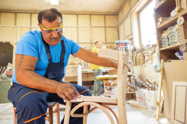 istock Indian carpenter working alone in his workshop. He is wearing safety glasses 1413289583