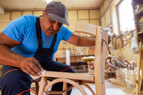 istock Indian carpenter working alone in his workshop in a squatting position 1413290060