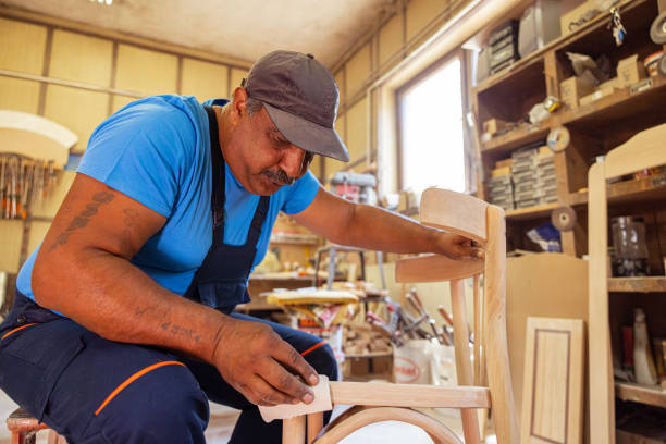 istock Indian carpenter working alone in his workshop in a squatting position 1413290068