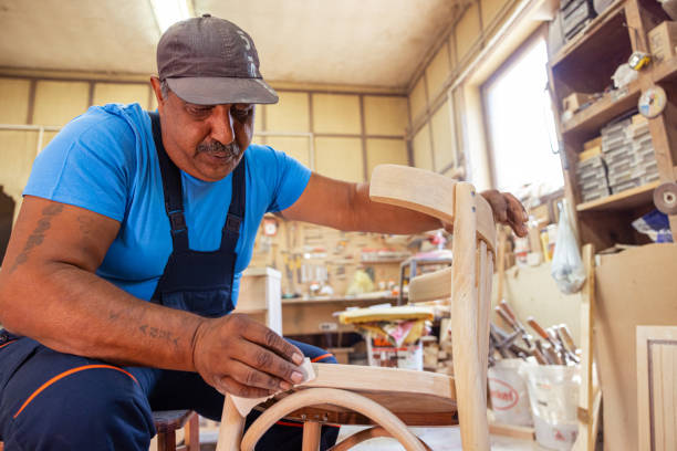 istock Indian carpenter working alone in his workshop in a squatting position 1413290073