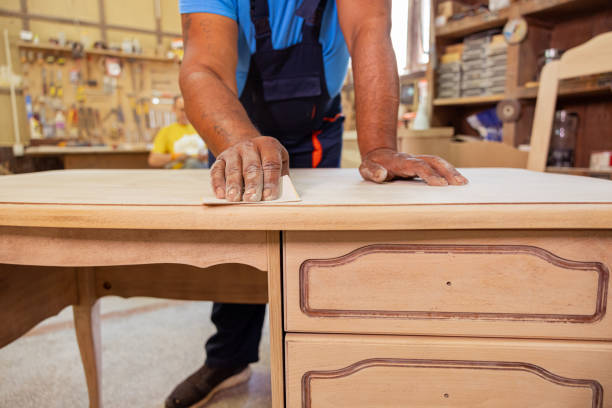 Indian carpenter making a wooden table. Removing rough surfaces on wood.