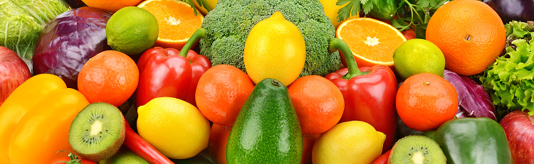 Bright background from a set of appetizing fruits and vegetables. Wide photo.