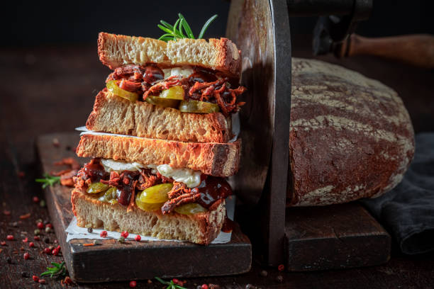 istock Delicious sandwich with pickles, pulled pork, sauce and rosemary. 1413294559