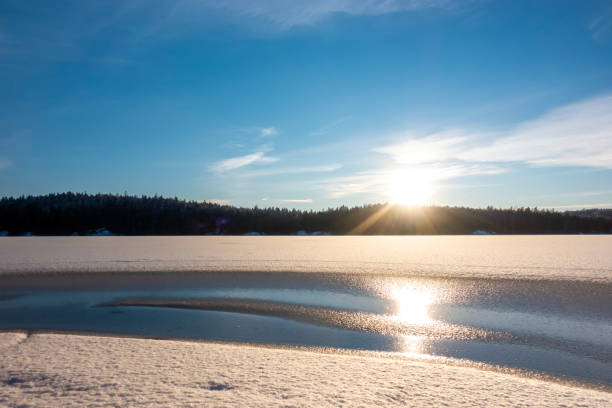 View over frozen lake covered in untouched snow in Scandinavia on a cold winter day near the Arctic circle
