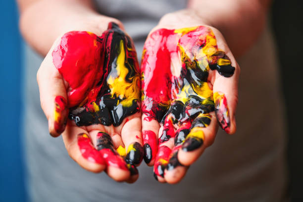 Women's palms painted with multi-colored acrylic paints close-up.