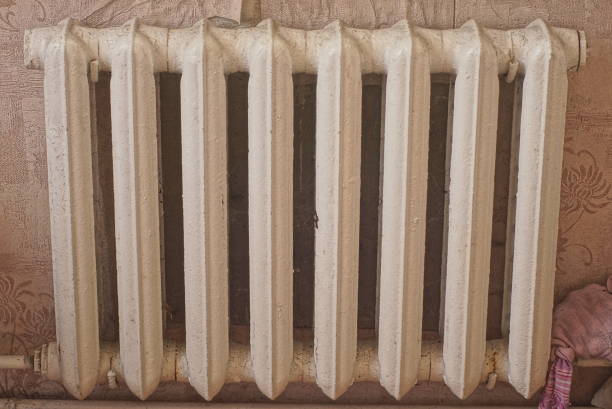 istock part of an old cast-iron white radiator in a brown wall 1413299657