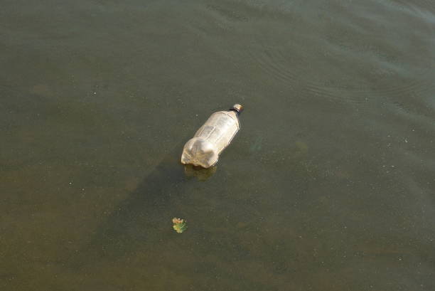 istock one old white plastic bottle lies in the gray water 1413299702