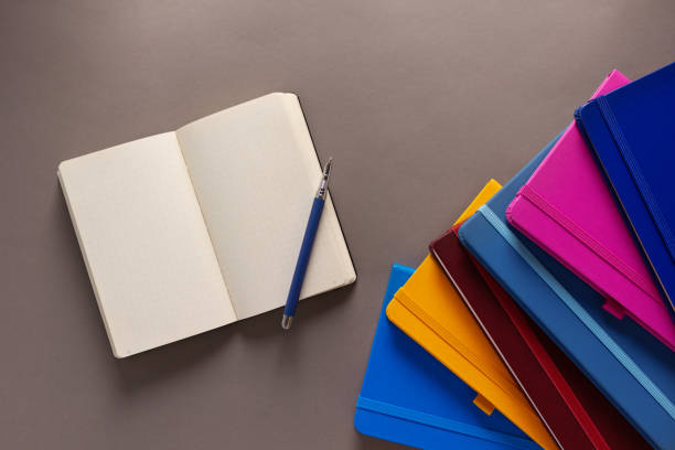 istock Open notepad and notebook heap on paper table background. Back to school concept idea 1413300330
