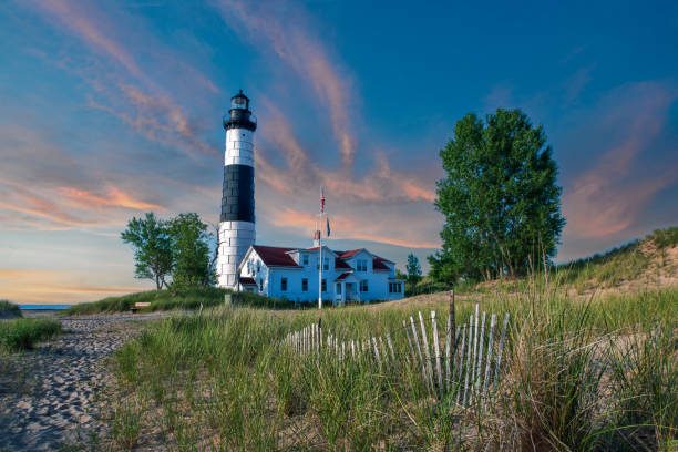 istock Lighthouse at Sunset with Sand Fence 1413300944