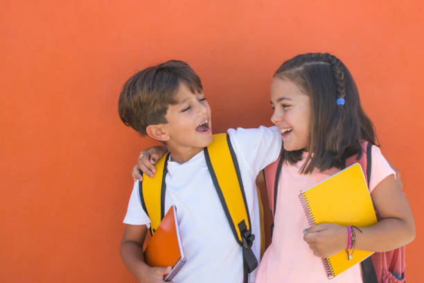 dzieci w wieku podstawowym z wyrazem radości pierwszego dnia szkoły. - schoolgirl child backpack book bag zdjęcia i obrazy z banku zdjęć