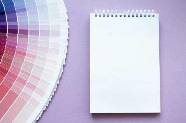 istock Paint samples, multi colour swatch for interior design. Light lilac background. White paper notebook for drawing or writing. Copy space 1413307729