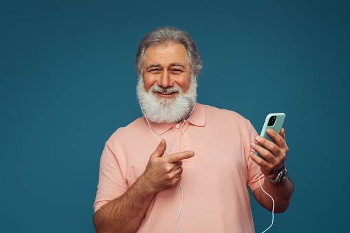 Portrait of emotional old man using smart phone