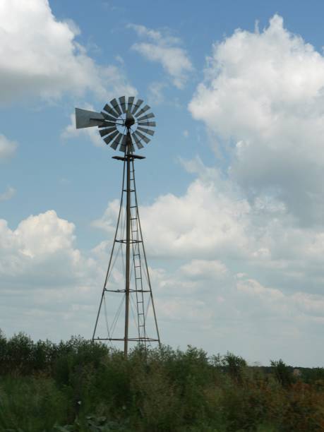 istock Small windmill in a farm, with beautiful clouds in the skies 1413314574