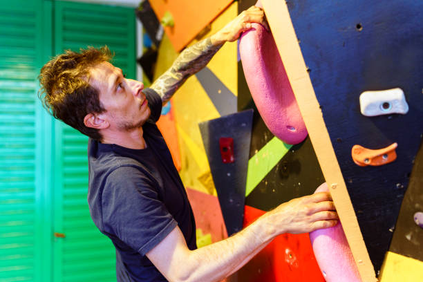 istock Man at an Indoor rock climbing gym 1413315462
