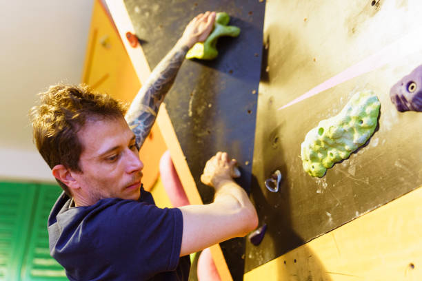 istock Man at an Indoor rock climbing gym 1413315520