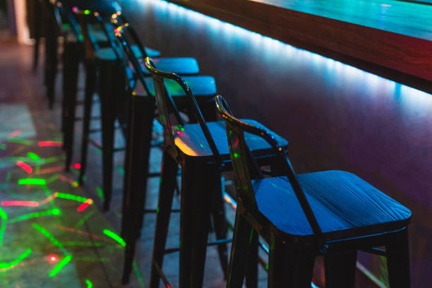 Chair in bar concept. Color neon light. Dark abstract background.