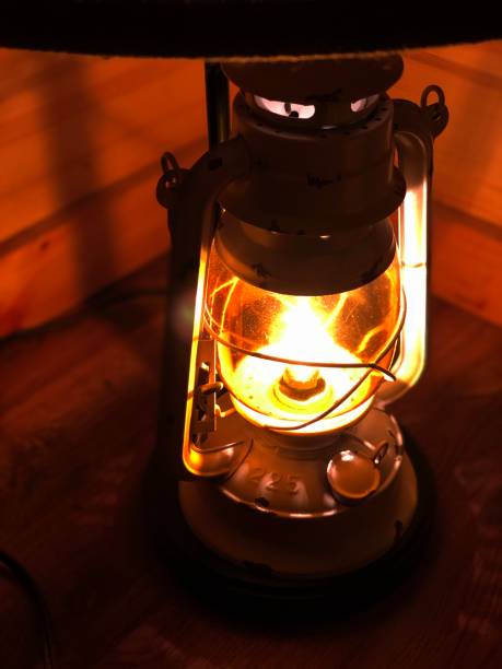 istock Lighted antique lamp light in a wooden cabin corner 1413316760