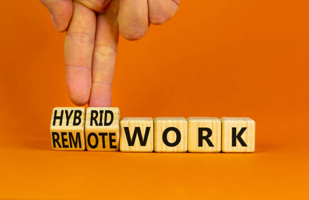 istock Hybrid or remote work symbol. Businessman turns cubes and changes words 'remote work' to 'hybrid work'. Beautiful orange background. Business, hybrid or remote working concept, copy space. 1413319082