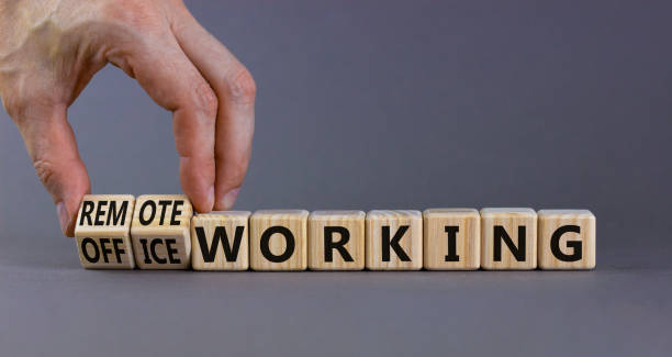 istock Office or remote working symbol. Businessman turns cubes and changes words 'remote working' to 'office working'. Beautiful grey background. Business, office or remote working concept, copy space. 1413319101