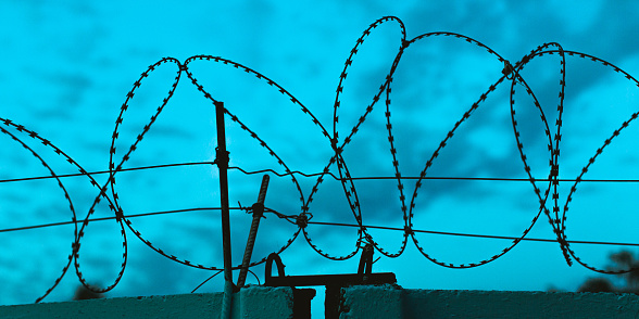 Barbed wire against the evening sky. Twilight. Prison concept. Freedom.