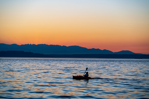 A kayaker enjoys a gorgeous Puget Sound Summer sunset viewed from West Seattle.
