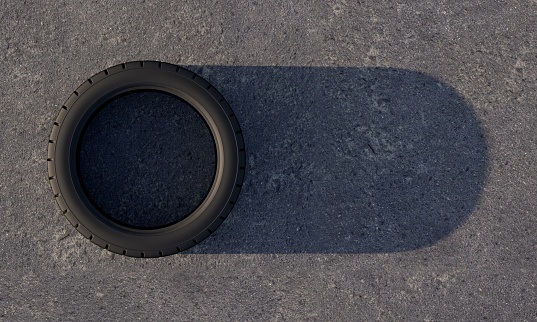 Car tire on asphalt with a shadow that looks like a switch slider button. Tire fitting concept. Copy space