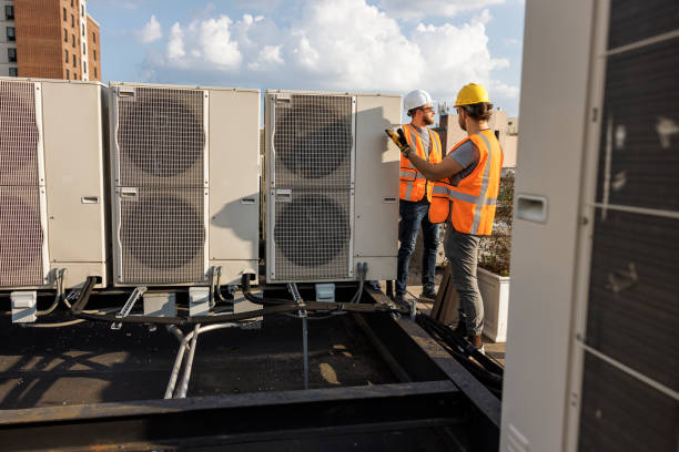 istock Air-conditioning unit inspection on a rooftop requires teamwork. Supervisor and worker checking air condition system and logging results with a portable computer. 1413326477