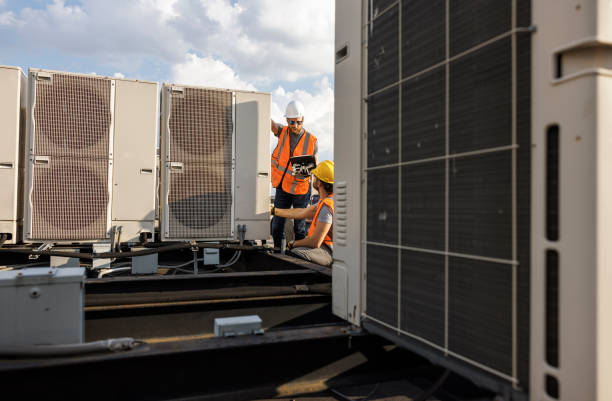 istock Aircondition units inspection on a rooftop. Supervisor and worker checking air condition system and logging results with a portable computer. 1413326479