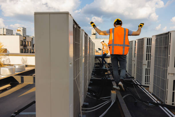istock Construction workers are checking air condition system units on the roof and logging results with a portable computer. 1413326489