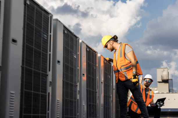 istock Aircondition units inspection on a rooftop. Supervisor and worker checking air condition system and logging results with a portable computer. 1413326502