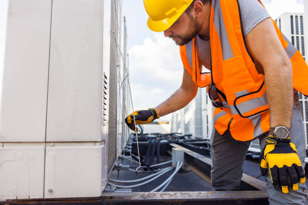 istock Blue collar worker fixing air condition unit on a rooftop. 1413326512