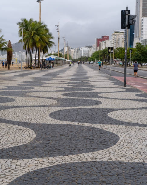 Morning view from Copacabana avenue in Rio Copacabana avenue, Rio de Janeiro city, Rio de Janeiro state, Brazil - October 03, 2021:People exercising in the morning on the most famous avenue from Rio. walking-in-copacabana-beach-sidewalk stock pictures, royalty-free photos & images