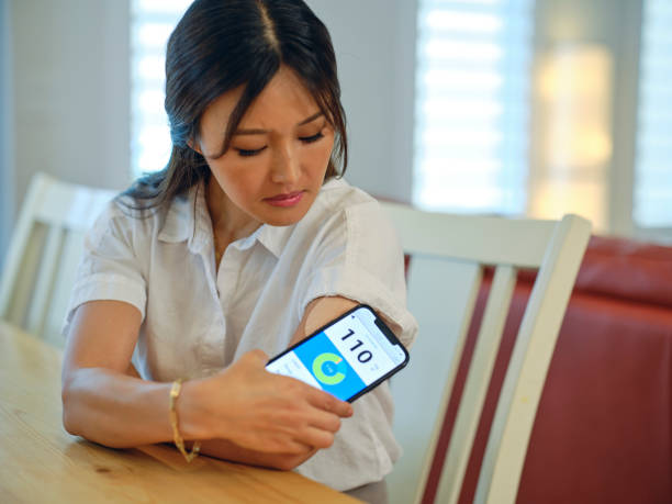 Home Healthcare A woman taking care of her health at home by checking her blood glucose level. diabetes stock pictures, royalty-free photos & images