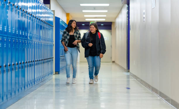 istock High school friends walking on a corridor alongside the lockers 1413334908