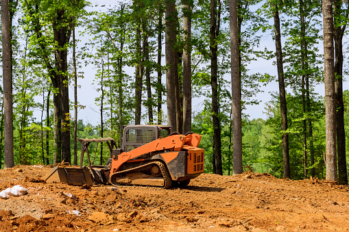A construction industrial grader is used in the process of leveling the land to prepare it to be used for new building