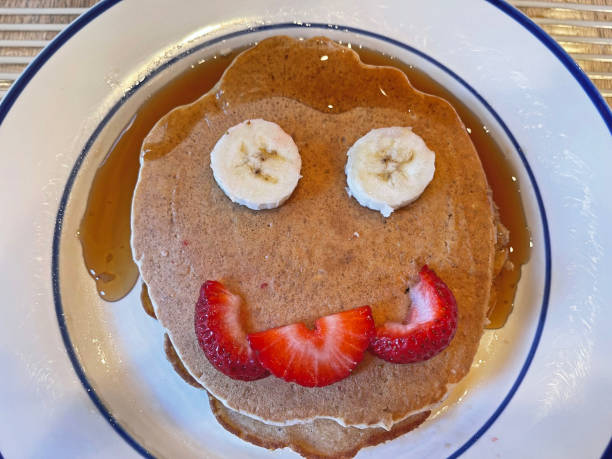 istock Stack of Pancake with Banana Eyes and Strawberry Mouth 1413354599