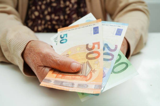 anciana jubilada que tiene dinero de billetes en euros y se preocupa por los gastos mensuales y el pago de la tarifa de tratamiento. - women poverty senior adult mature adult fotografías e imágenes de stock