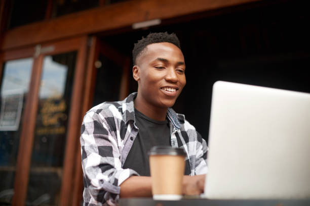 istock Creative entrepreneur typing on a laptop, browsing and searching startup business ideas in a cafe. Happy, confident and proud student learning a remote education course on technology in a restaurant 1413362414