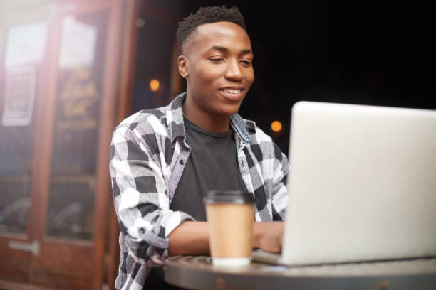 istock Creative entrepreneur typing on laptop, browsing and searching startup business ideas in a cafe. Happy man, confident and proud remote blogger, student or freelancer with online blog in a restaurant 1413362416