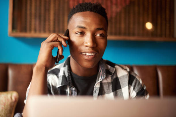 istock Working, talking and creative entrepreneur on phone call and networking with clients and customers in cafe. Brainstorming and sharing startup business ideas on technology in a restaurant 1413363338