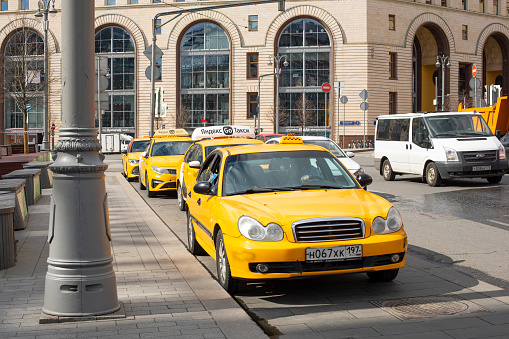 Moscow, Russia - May 4, 2022: Yellow city taxi in the capital, Lubyanskaya square in Moscow