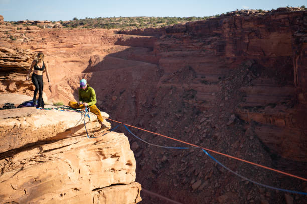 Young couple checking if ropes are correctly set for slack lining
