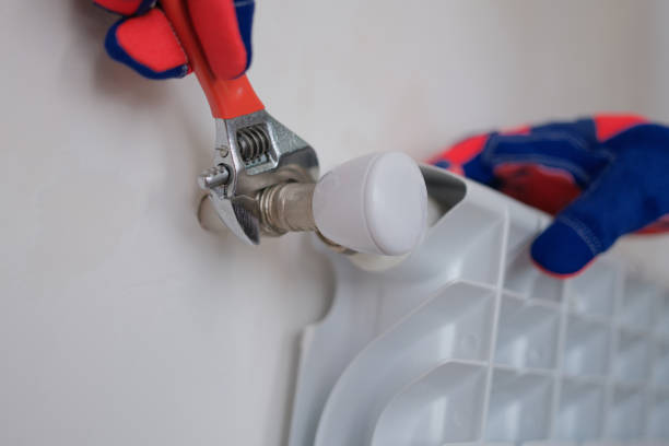 istock Plumber installing heating radiator in apartment or house 1413372342
