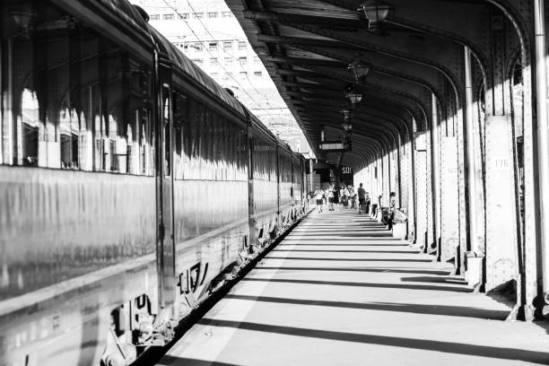 Ferrara, Italy - March 5, 2011: travelers standing at the platform with a train in motion.