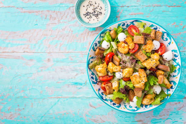 здоровый салат из курицы-гриль цезарь с сыром и сухарями - grilled chicken salad salad dressing food стоковые фото и изображения