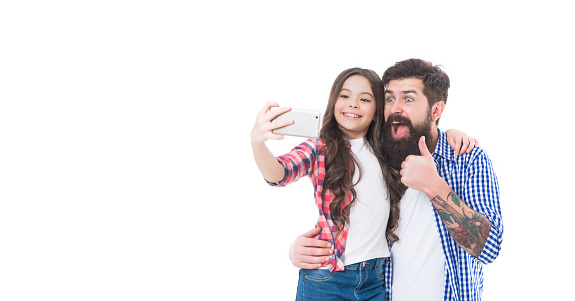 Smile to the camera. Girl child and bearded man take selfie with smartphone. Mobile selfie. Thumbs up. Happy family. Childhood and fatherhood. Mobile technology.