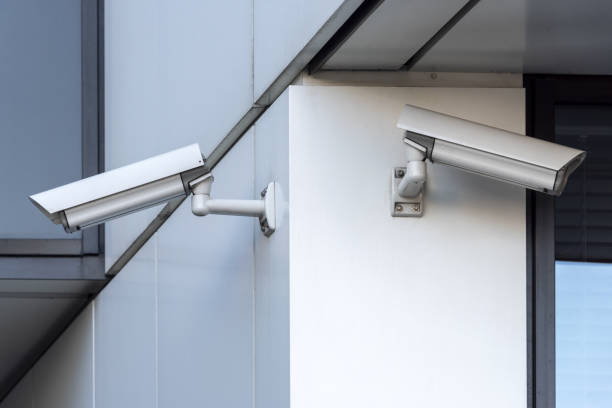 istock Security cameras on modern building. Professional surveillance camera. CCTV on the wall with LED IR lights. Security system, technology concept. Video equipment for safety system area control outdoor 1413383986