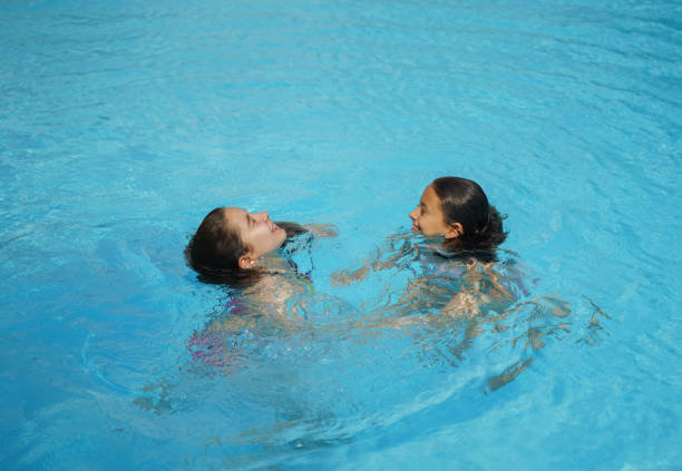 istock Smiling kids enjoying in swimming pool 1413384146