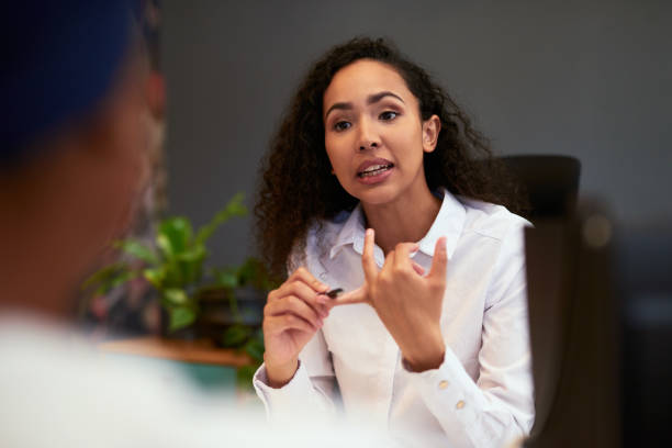 wütender, ernsthafter und frustrierter manager, chef oder führungsbeamter, der einen mitarbeiter feuert und streiks während einer mitarbeiterversammlung zählt. weibliche ceo, die den mitarbeitern den verlust von arbeitsplätzen und die finanzkrise erkl - herrisch stock-fotos und bilder