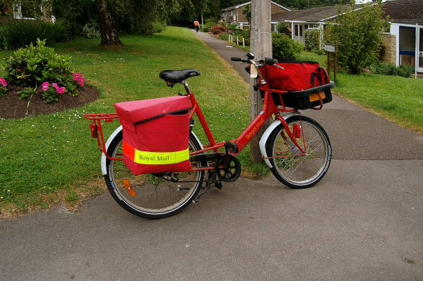 Red Royal Mail bicycle  parked for delivery posts to countryside houses,  Devizes, Wiltshire, England, UK. 2006